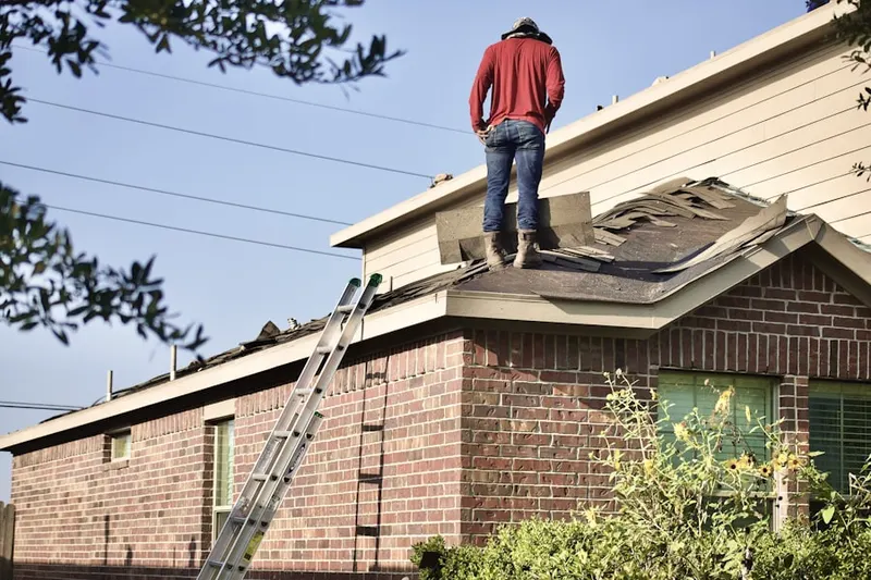 Professional roofer working on a residential roof in Baker Bridge